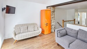 A modern living room with a beige sofa, a gray sofa, and an orange cabinet. - Host Stay The Duck Pond (Durham)