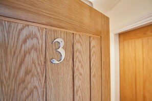 A wooden door with a metal number '3' indicating room number.