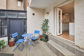 Relax in a cozy outdoor space with a deck, comfortable seating, and a potted plant.