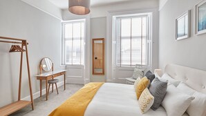 Une chambre à coucher comprenant un lit, une table de chevet, un miroir et une armoire.