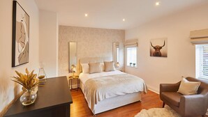 A bedroom with a large bed, bedside tables, a chair, and artwork on the walls. - Host Stay Newsam Crescent (Stockton-on-Tees)