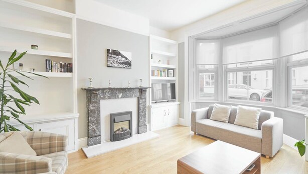 A modern living room with a fireplace, a sofa, a coffee table, and a bookshelf. - Host Stay Victorian Seahouse (Saltburn-by-the-Sea)