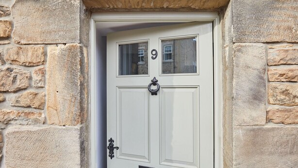 A white door with the number 9, a knocker, and a mail slot. - Host Stay Kenmore (Corbridge)