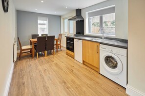 A compact kitchen with a dining area, built-in appliances, and a view through the window.