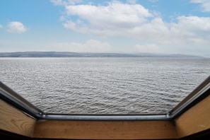 A view from a window overlooking a body of water with distant land and a clear sky. - Host Stay Freshwater River View (Dunoon)