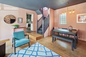 Cozy interior space with a dining table, bench, and staircase leading to an upper level.