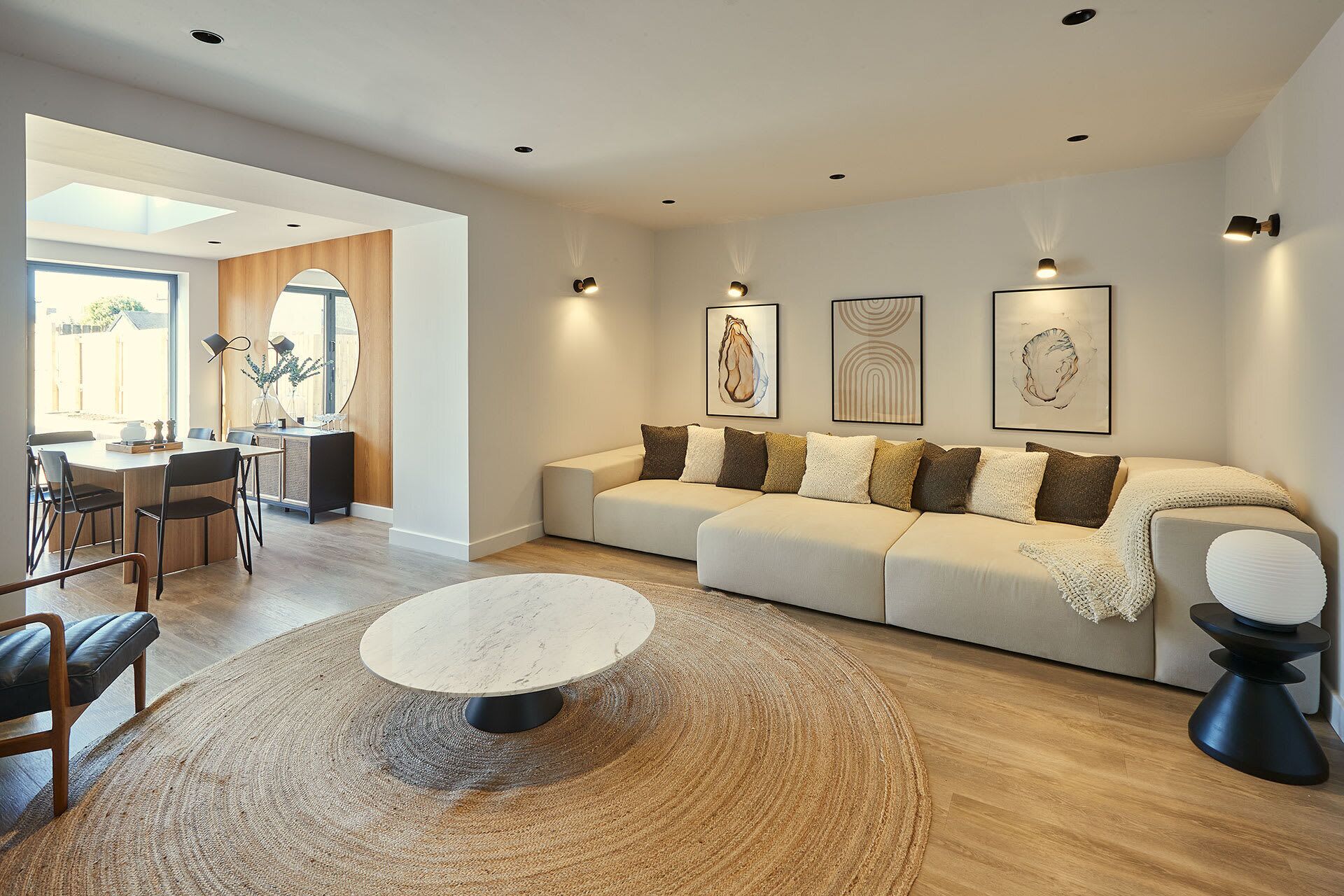 Una sala de estar moderna con sofá, mesa de centro y una obra de arte en la pared.