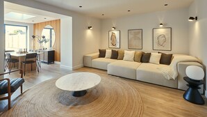 A modern living room with a sofa, coffee table, and artwork on the wall. - Host Stay Taylor Street (Seahouses)