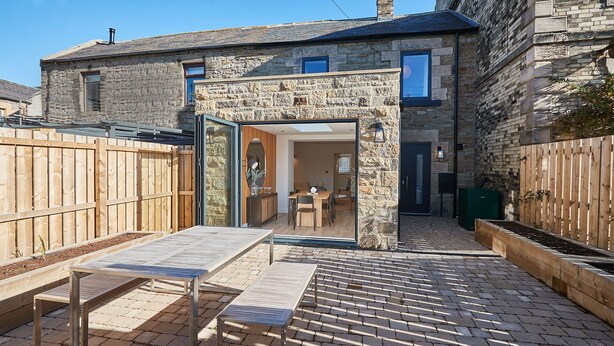 A stone house with a wooden deck, a dining area, and a garden. - Host Stay Taylor Street (Seahouses)