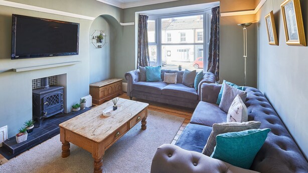 A living room with a sofa, a coffee table, a fireplace, and a television. - Host Stay High Street (Saltburn-by-the-Sea)