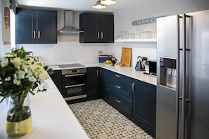 Enjoy cooking in this kitchen with sleek cabinetry, a stainless steel refrigerator, and oven.