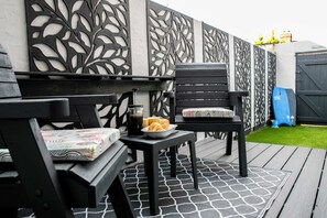 Relax in this stylish seating area with a table, chairs, and a decorative wall.