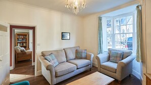 A living room with two sofas, a coffee table, and a bookshelf. - Host Stay Hall Garth (Pickering)