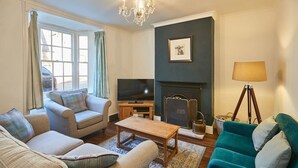 A living room with a fireplace, a television, and a chandelier. - Host Stay Hall Garth (Pickering)