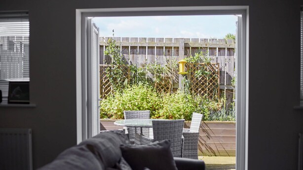 Une pièce donnant sur un jardin, avec une porte vitrée.
