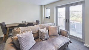 Un salon confortable avec un canapé, une table à manger et une grande fenêtre.