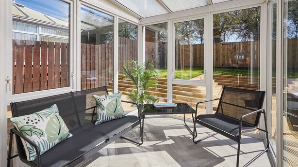 A conservatory with a glass ceiling, a sofa, a chair, and a small table. - Host Stay Cleveland Rest (Saltburn-by-the-Sea)
