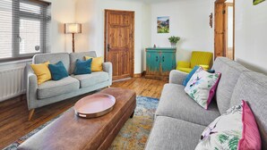 A cozy living room with a grey sofa, a wooden coffee table, and a teal cabinet. - Host Stay Cleveland Rest (Saltburn-by-the-Sea)