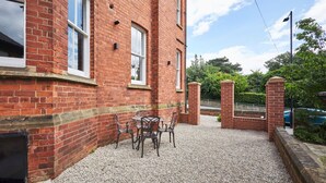 A brick building with a gravel patio and outdoor seating area.