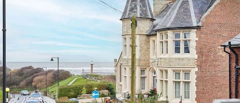 A coastal building with a prominent tower, a view of the sea, and a sign reading "STREON".