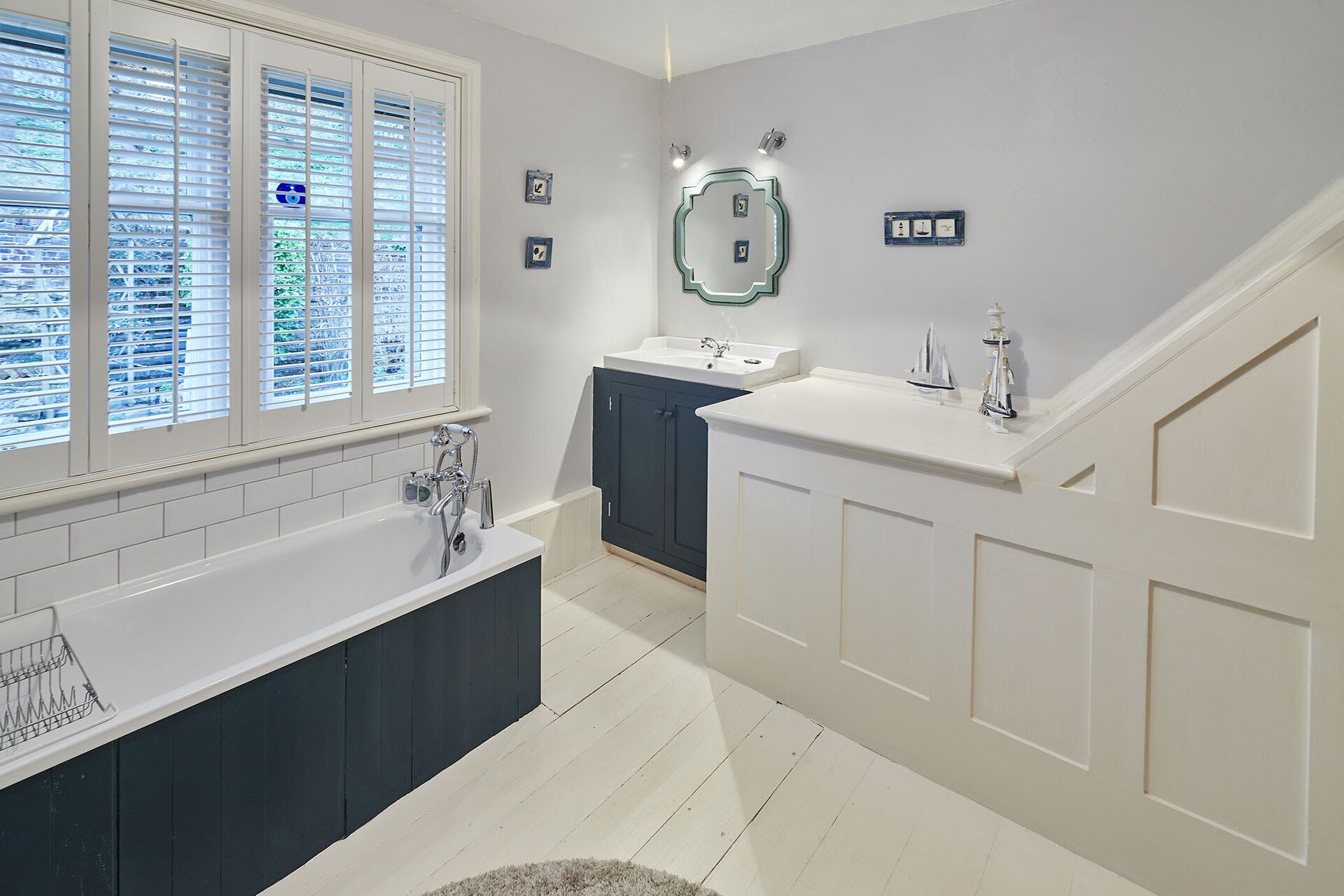 A modern bathroom with a freestanding bathtub, a vanity with a sink, and a large mirror.