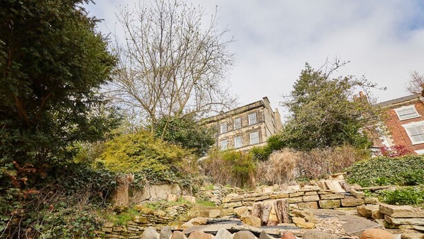 A stone wall with a stone staircase leading up to a building. - Host Stay Scoresby Place (Whitby)