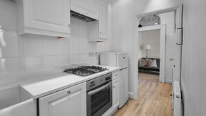 A modern kitchen with white cabinetry, a gas stove, and an oven. - Host Stay Scoresby Place (Whitby)