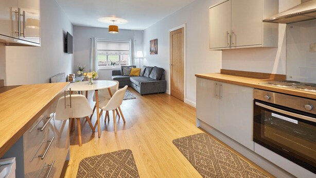 A modern kitchen with a dining area, a sofa, and a window. - Host Stay Britton Hall Bungalow (Bishop Auckland)