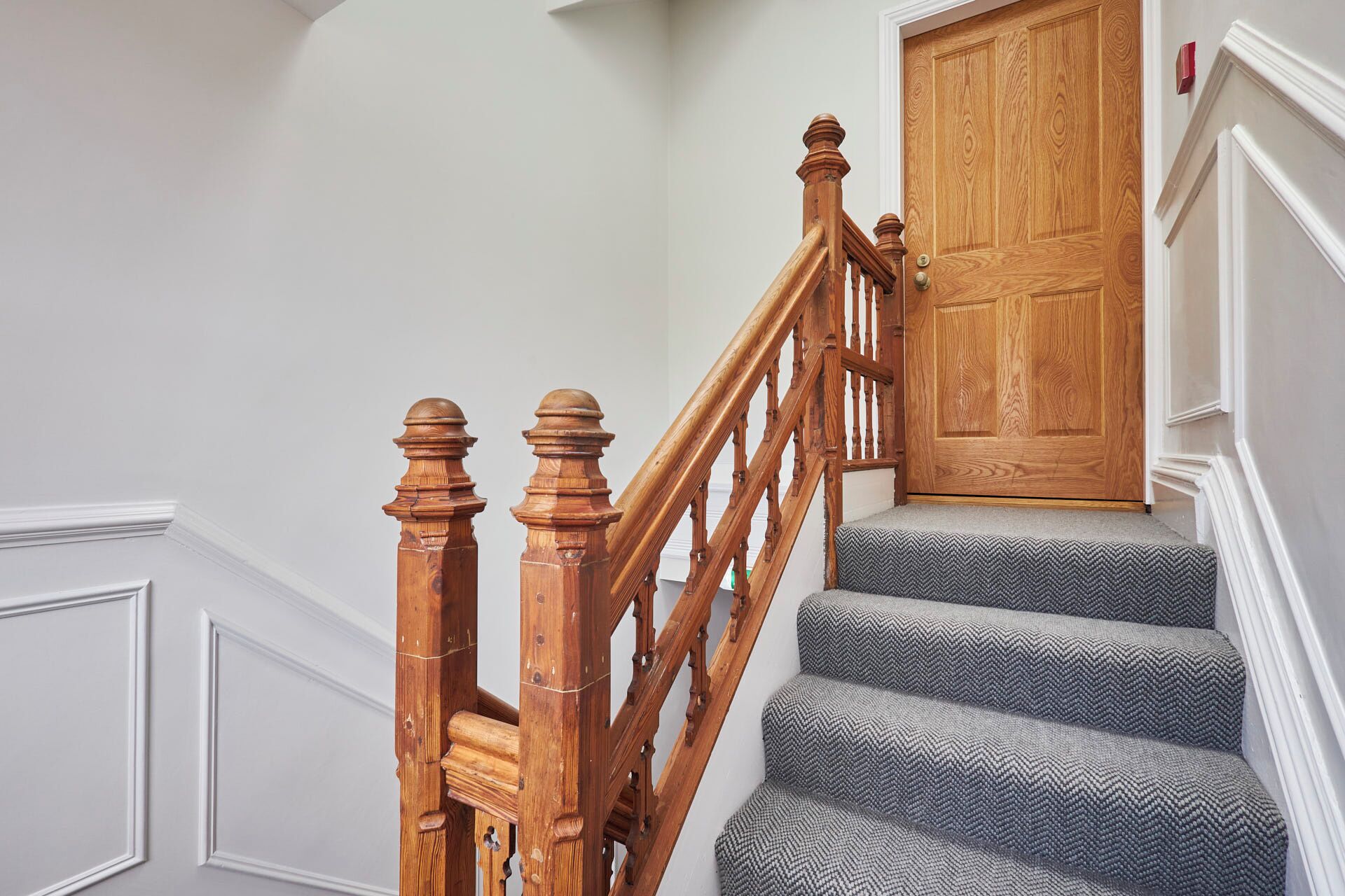 A wooden staircase with a wooden door at the top.