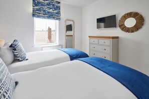 Relax in a serene space with a large bed, bedside tables, and a wall-mounted TV.