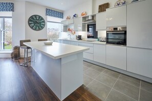 Enjoy cooking in this kitchen with a central island and stainless steel appliances, including an oven and coffee maker.