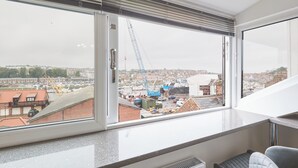 Une chambre moderne avec une grande fenêtre donnant sur un chantier de construction.