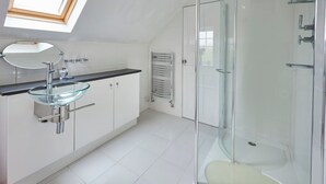 A modern bathroom with a glass-enclosed shower, a glass sink, and a skylight. - Host Stay The Paddock (Bedlington)