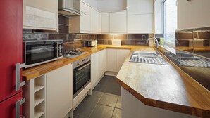 Eine kompakte Küche mit Backofen, Mikrowelle und Gasherd.