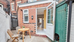 A small, cozy room with a single bed, a window, and a door leading to a green garage. - Host Stay Northville Arrifana (Whitley Bay)