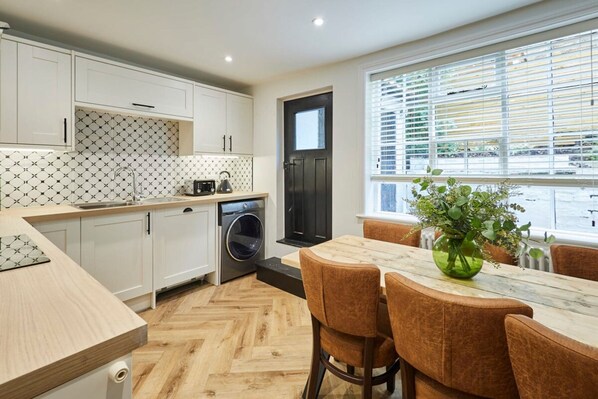 Enjoy cooking in this well-equipped kitchen with washing machine and adjacent dining area.