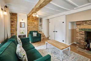 Relax in this inviting living room with a green sofa, wooden coffee table, and traditional rug.