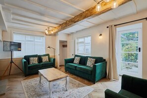 Relax in this inviting living room with a high ceiling, two sofas, a coffee table, and a floor lamp.