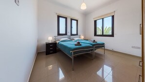 Una habitación con dos camas, una mesita de noche, una lámpara y una luz en el techo.