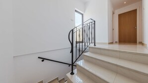 Una escalera con barandilla de metal negro que lleva a una plataforma.
