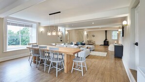 A spacious living area with a wooden dining table and chairs, a sofa, and a fireplace. - Host Stay Stay House (Thirsk)