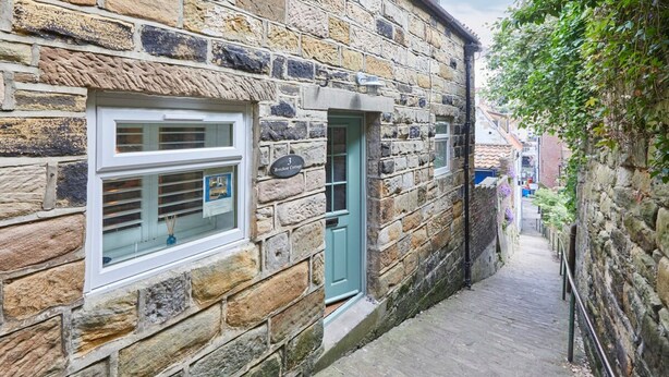 A narrow stone building with a window and a door, labeled "Breakers Cottage." - Host Stay Breckon Cottage (Whitby)