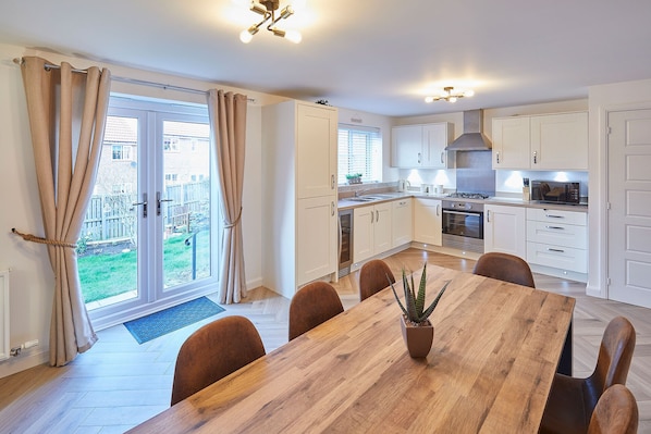 Enjoy meals in the kitchen with stainless steel appliances and a central island, surrounded by a dining area with a wooden table and six chairs.