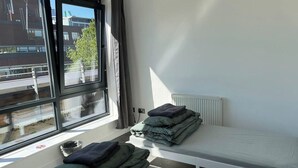 Ett rum med en säng, ett fönster och ett element.