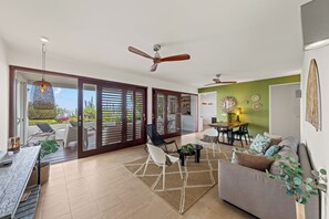 Een ruime woonkamer met een eettafel, een bank en uitzicht door een schuifdeur op een terras.