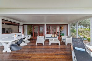 A modern interior with a dining area, seating, and a view of the outdoors. - Ocean View Apartment Bayside, 6 guests - Boca Gentil, Jan Thiel area (Jan Thiel)