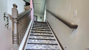 Eine Treppe mit einem gemusterten Fliesenbelag auf den Stufen und einem dunklen Boden.