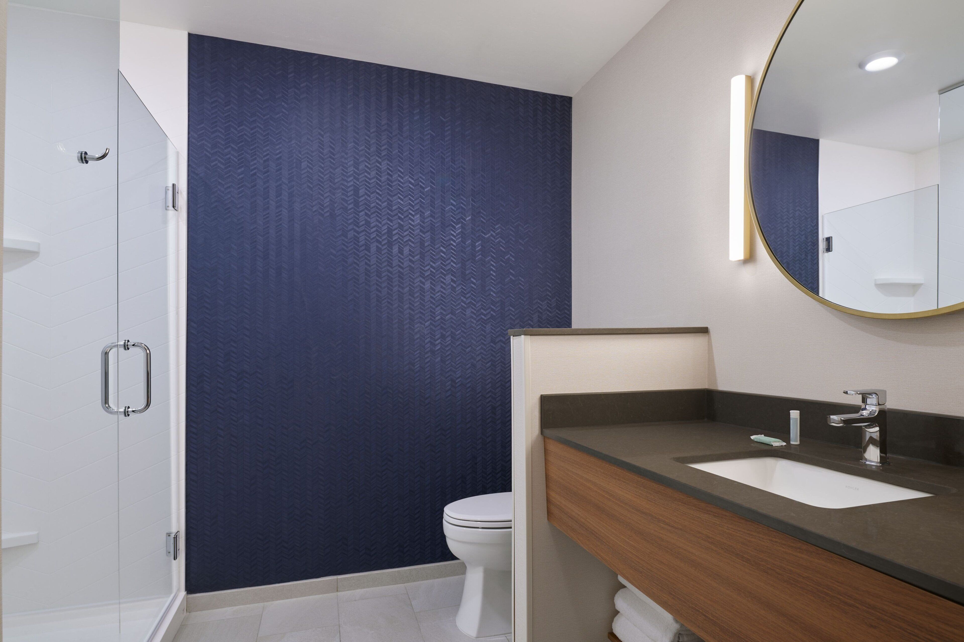 Een moderne badkamer met douche, toilet en een wastafel.