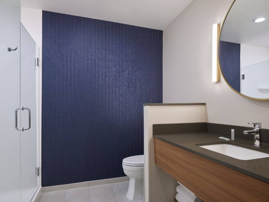 Een moderne badkamer met douche, toilet en een wastafel.