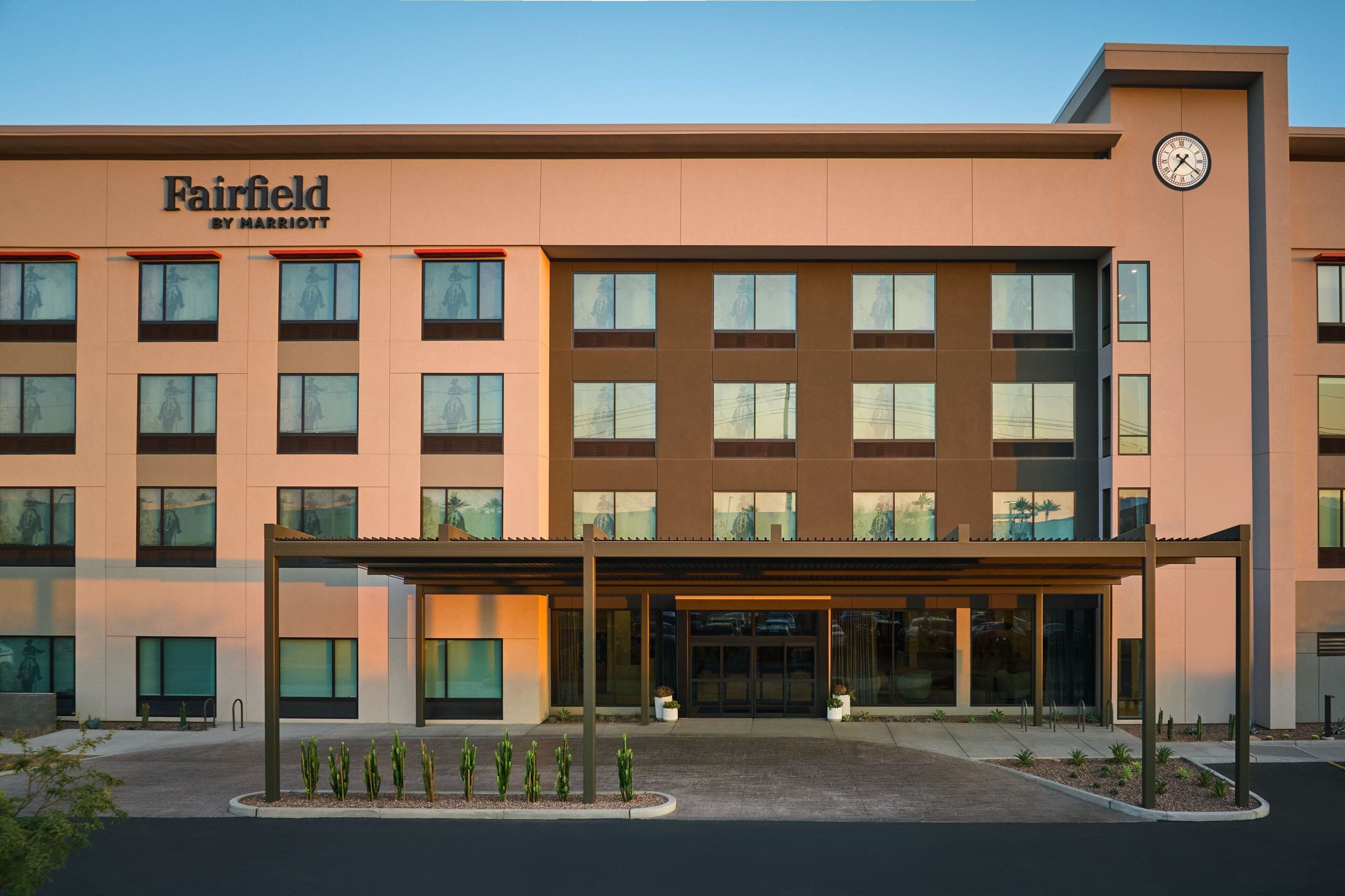 Een Fairfield by Marriott hotel met een moderne gevel, meerdere ramen en een klok aan de rechterkant.